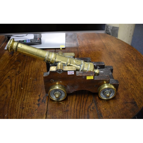 1726 - A pair of 19th century brass starting cannons, 38cm long, each on mahogany four wheel carriage.... 