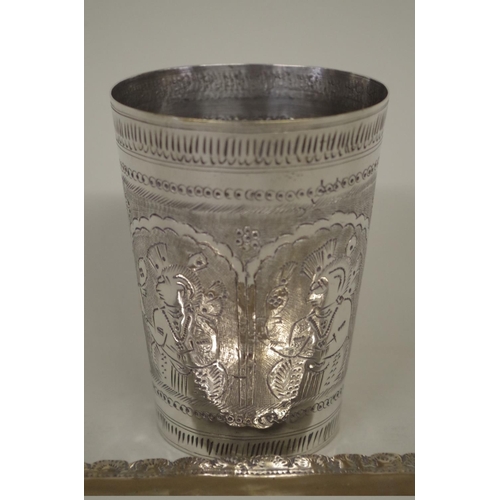 78 - A metal beaker decorated figures, 11cm high; together with a metal pin tray, 22.5cm long. *Please no... 