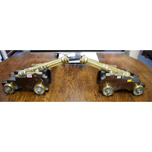 1726 - A pair of 19th century brass starting cannons, 38cm long, each on mahogany four wheel carriage.... 