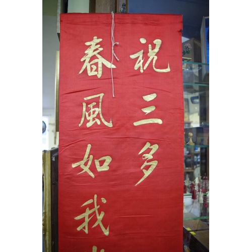 725 - A Chinese red silk panel, gilt painted with script, 190 x 35cm; together with three C... 