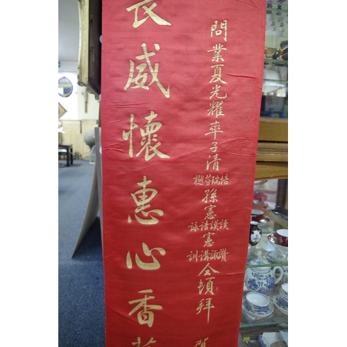 725 - A Chinese red silk panel, gilt painted with script, 190 x 35cm; together with three C... 