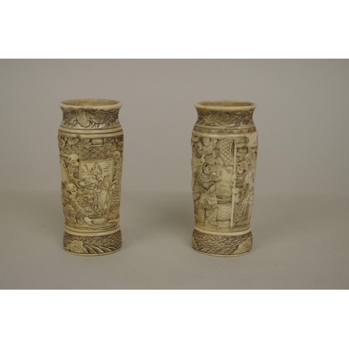 729 - A small pair of Japanese bone vases, 19th century, carved in relief with figures, 9.5cm high.... 