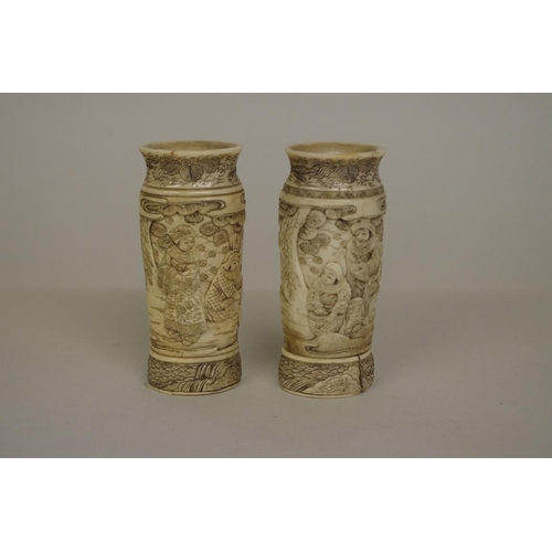 729 - A small pair of Japanese bone vases, 19th century, carved in relief with figures, 9.5cm high.... 