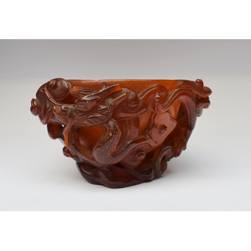 732 - A very rare Chinese carved amber libation cup, 17th century, carved in high relief with dragons and ...
