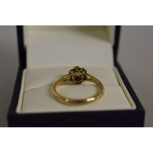 276 - A gold diamond daisy ring, stamped 18ct.... 