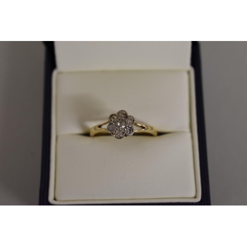 276 - A gold diamond daisy ring, stamped 18ct.... 