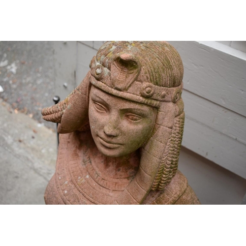 1205 - An old red composition stone figure of a semi-nude Egyptian woman, 82cm high, (repairs).... 