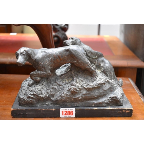 1286 - A bronzed figure group of two gundogs, inscribed 'GP', 23.5cm wide, on wood base.... 