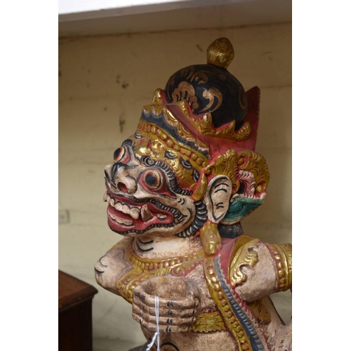 1291 - A Balinese carved and polychrome painted mythical figure, 50cm high.