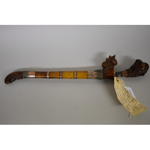 1720 - An Indonesian bade bade knife, having 23cm script inscribed blade, with carved wood parrot head pomm... 