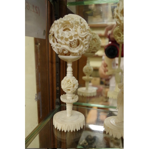 1797 - Two Chinese ivory concentric puzzle balls on stands; together with another Chinese carved ivory vase... 