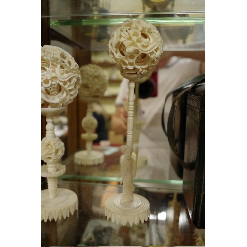 1797 - Two Chinese ivory concentric puzzle balls on stands; together with another Chinese carved ivory vase... 