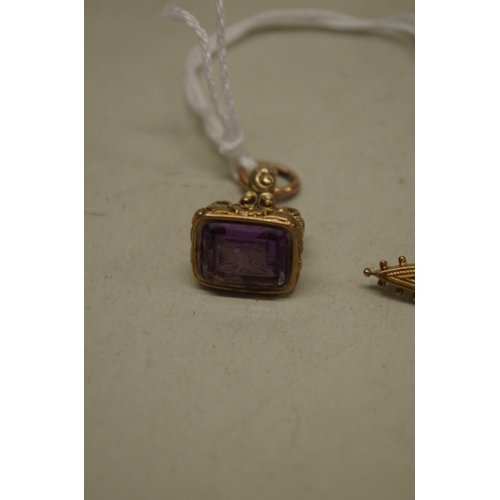 152 - A yellow metal fob seal set carved amethyst, of galleon upon a sphere with trailing flower; together... 