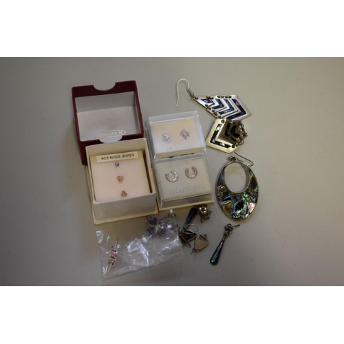 193 - A selection of silver and shell set earrings, to include other metal examples.