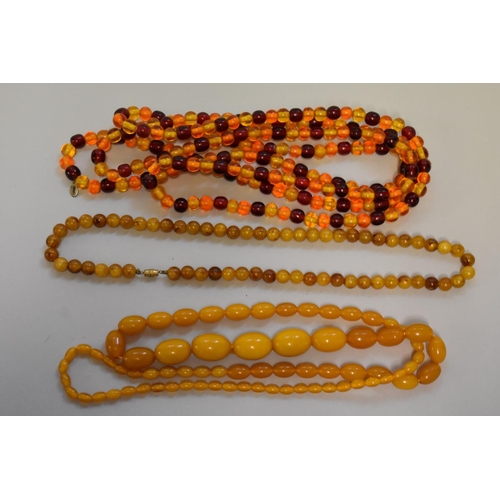 197 - Three strings of amber coloured beads.