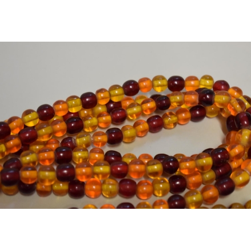 197 - Three strings of amber coloured beads.