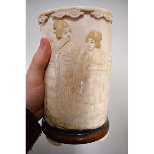 554 - A Japanese ivory tusk vase and cover, Meiji, carved in relief with a figure and geishas in a garden,... 