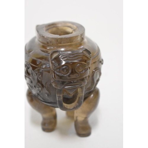 556 - A Chinese smokey quartz or agate twin handled tripod censer and cover, with taotie mask decoration, ... 