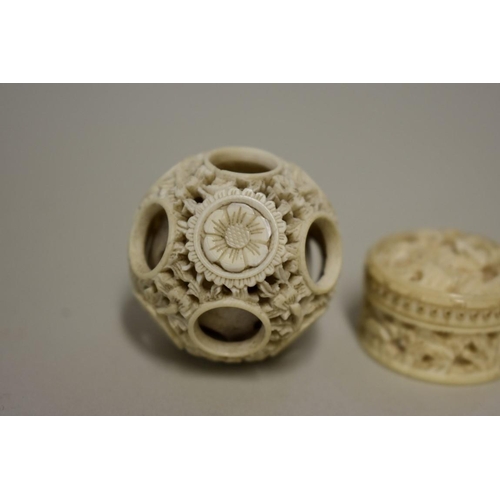 560 - A Chinese carved ivory concentric puzzle ball, 3.6cm diameter; together with another small carved iv... 