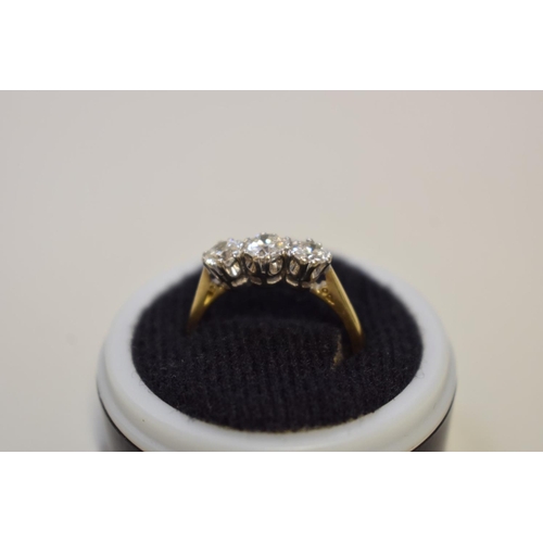 64 - A brilliant cut diamond three stone gold ring, hallmarked 750, 0.75ct approximately, 4.2g total weig... 