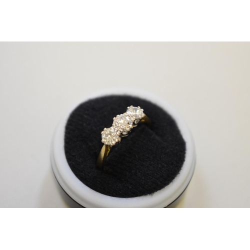 64 - A brilliant cut diamond three stone gold ring, hallmarked 750, 0.75ct approximately, 4.2g total weig... 