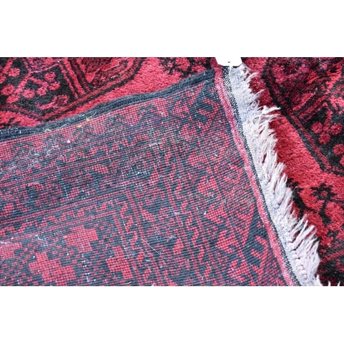 1120 - A Bokhara carpet, having repeated medallions to central field on a red ground; together with a ... 