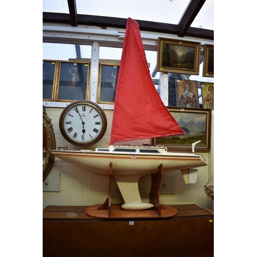 1182 - A large pond yacht, the hull 125.5cm long, on plywood stand.