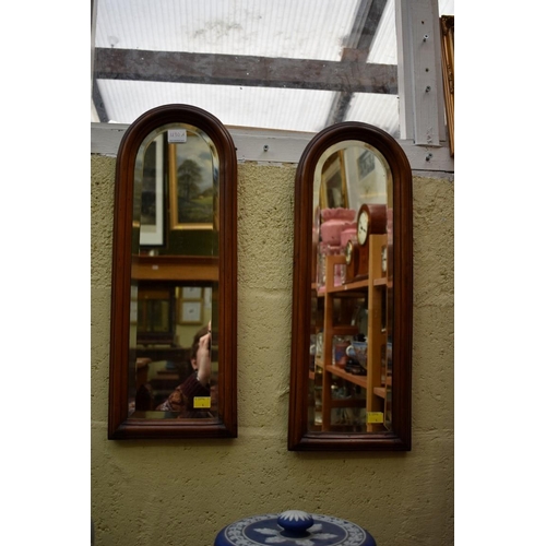 1190A - A small pair of mahogany framed arched wall mirrors, 55.5 x 20.5cm.