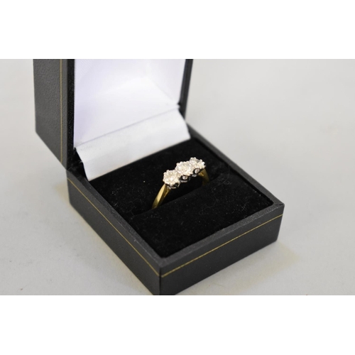 64 - A brilliant cut diamond three stone gold ring, hallmarked 750, 0.75ct approximately, 4.2g total weig... 