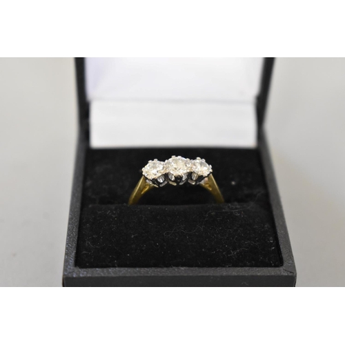 64 - A brilliant cut diamond three stone gold ring, hallmarked 750, 0.75ct approximately, 4.2g total weig... 