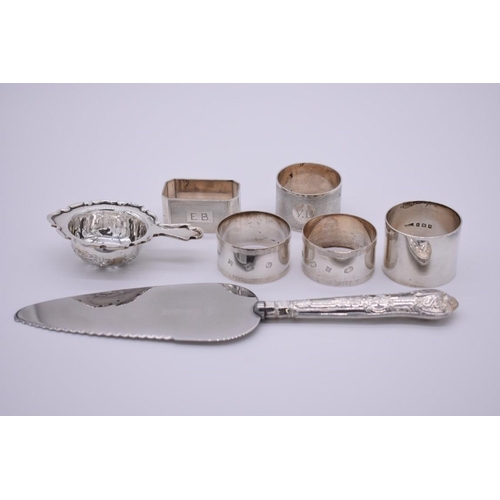 364 - A small collection of silver items, to include; five napkin rings; and a tea strainer etc, 248g weig... 