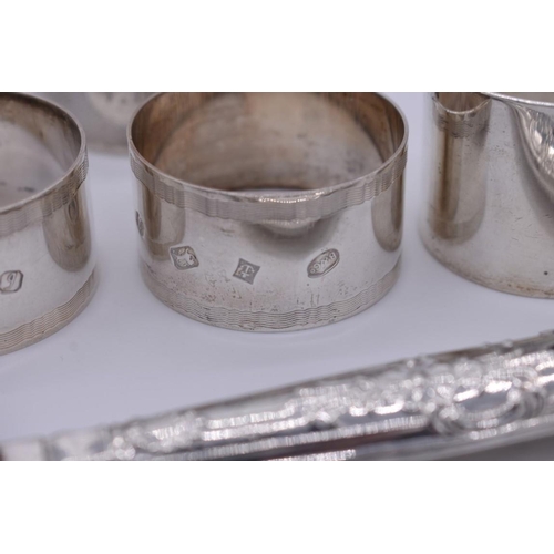 364 - A small collection of silver items, to include; five napkin rings; and a tea strainer etc, 248g weig... 