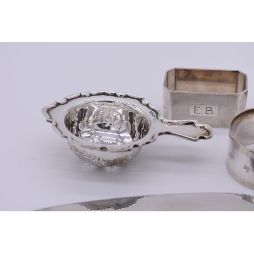 364 - A small collection of silver items, to include; five napkin rings; and a tea strainer etc, 248g weig... 