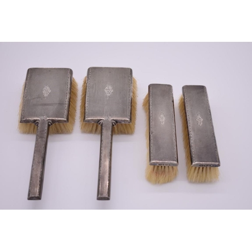 393 - A silver engine turned four piece brush set, by Garrard & Co Ltd, Birmingham 1954.... 