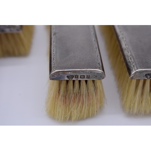 393 - A silver engine turned four piece brush set, by Garrard & Co Ltd, Birmingham 1954.... 