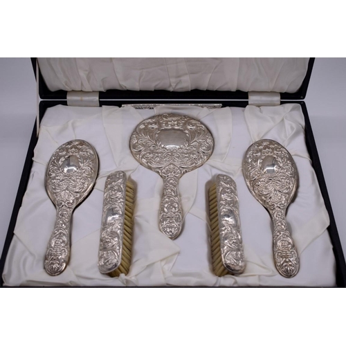 396 - A cased repousse silver six piece dressing set, by W I Broadway & Co, Birmingham 1977.... 