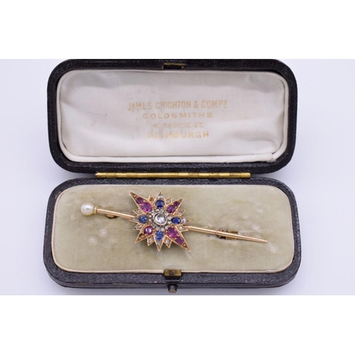 399 - A sapphire, ruby and diamond yellow metal starburst cravat pin, having pearl finial, in fitted case,... 