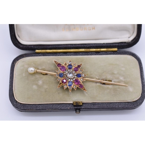 399 - A sapphire, ruby and diamond yellow metal starburst cravat pin, having pearl finial, in fitted case,... 