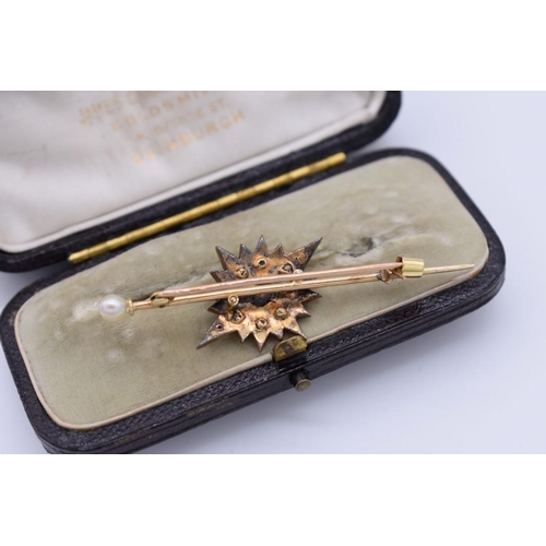 399 - A sapphire, ruby and diamond yellow metal starburst cravat pin, having pearl finial, in fitted case,... 