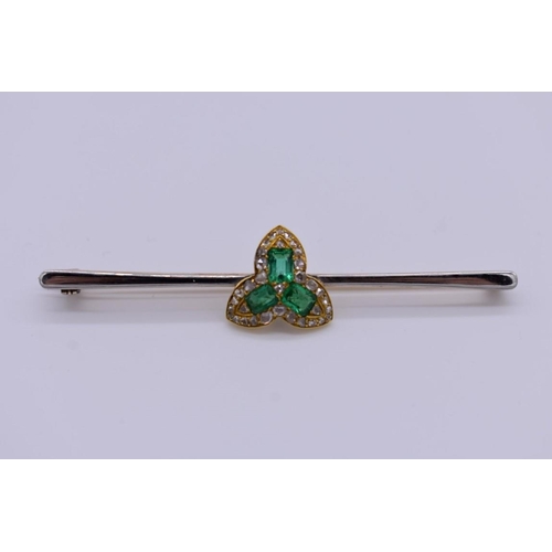 402 - An emerald and diamond yellow and white metal bar brooch, 6.5cm across, 7.1g total weight.... 