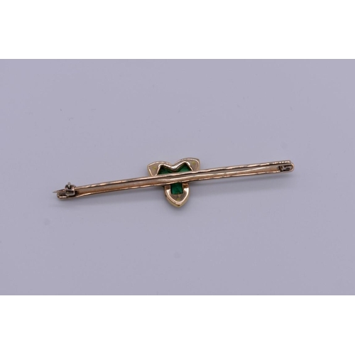 402 - An emerald and diamond yellow and white metal bar brooch, 6.5cm across, 7.1g total weight.... 