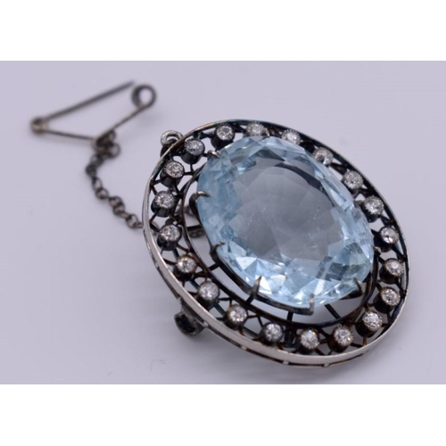 404 - An Edwardian aquamarine and diamond unmarked brooch, the large oval stone measuring 17 x 21 x 12mm a... 