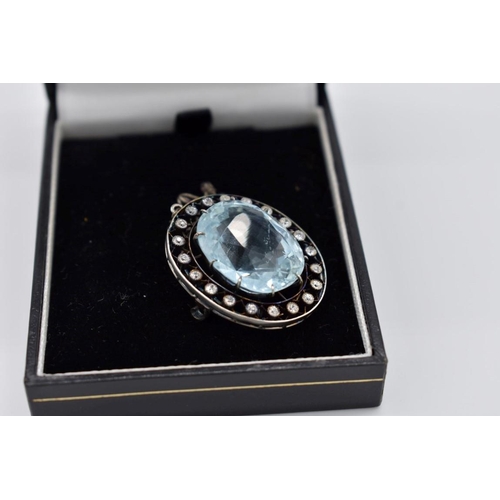 404 - An Edwardian aquamarine and diamond unmarked brooch, the large oval stone measuring 17 x 21 x 12mm a... 