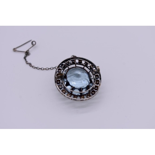 404 - An Edwardian aquamarine and diamond unmarked brooch, the large oval stone measuring 17 x 21 x 12mm a... 