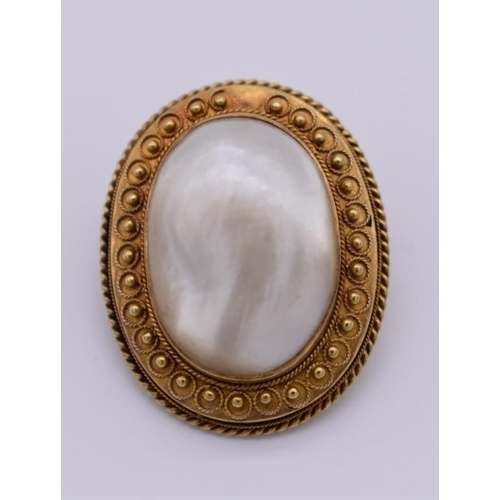 405 - A Victorian baroque mother of pearl oval gold brooch, 3.3 x 2.5cm, 13.2g total weight, (tested as 15... 