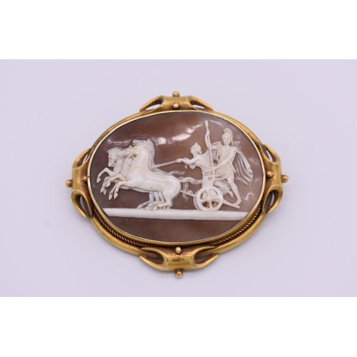 406 - A Victorian carved shell cameo yellow metal brooch, depicting Roman charioteers, 7cm wide.... 