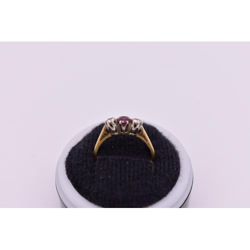 418 - A three stone ruby and diamond gold ring, stamped 18ct and plat, 2.8g.