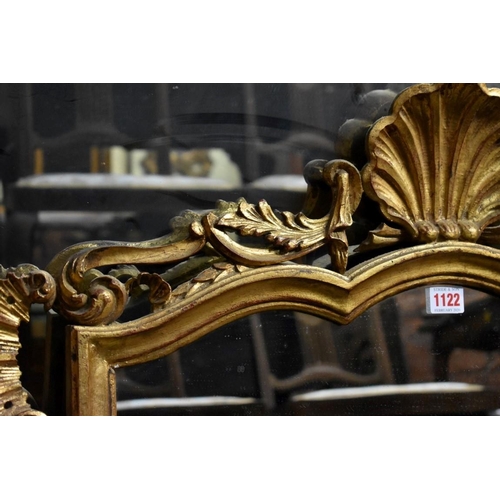 1122 - (HP) A reproduction gilt framed wall mirror, with shell crest, 111 x 77cm. ... 