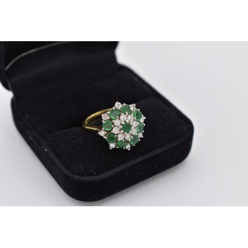 106 - An emerald and diamond cluster gold ring, stamped 18ct, 5.2g total weight.