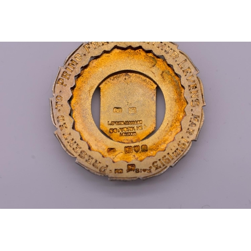 121 - A silver gilt and enamel presentation medallion, by Louis Symelman, London 1912, 23.2g total we... 